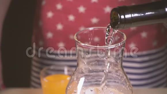 慢动作的葡萄酒倒入装有水和冰的玻璃瓶中视频的预览图