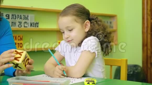 漂亮的小女生漂亮的发型和美丽的微笑穿着一件白色的衬衫坐在她的办公桌前视频的预览图