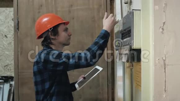梦想中的微笑修理工把平板电脑放在老楼里测试电工视频的预览图