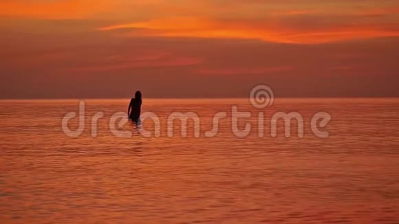 女人的剪影欣赏大海中的日落慢动作1920x1080视频的预览图