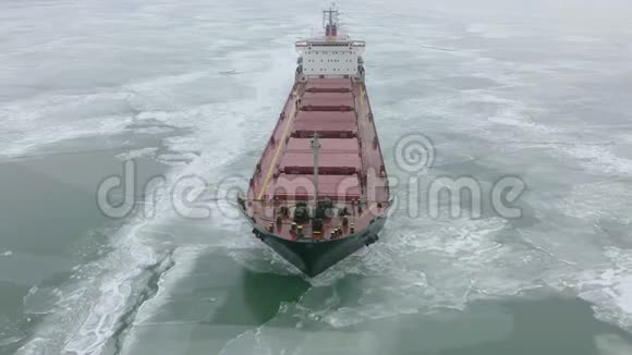 在极端的冬季条件下货船在冰冻的海面上航行在狭窄的航道上航行视频的预览图