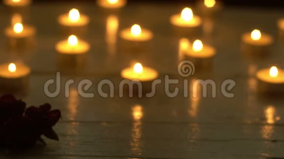 白色书桌上有玫瑰花点燃的浪漫蜡烛视频的预览图