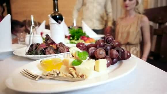 餐厅的餐桌上有美味的食物肉葡萄奶酪蜂蜜和葡萄酒提供给游客咖啡馆后台视频的预览图