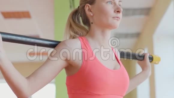 一位年轻女子在健身馆蹲着的侧视图视频的预览图