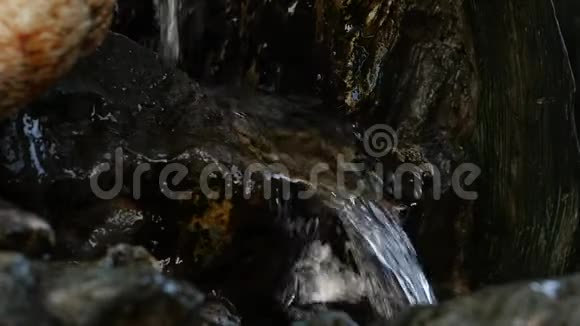 岩石山的小瀑布水在岩石小径上流淌慢动作视频的预览图