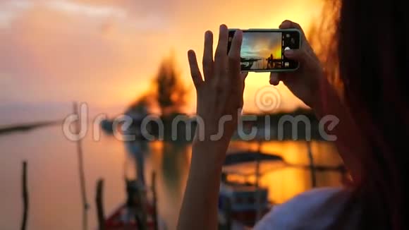 白种人女孩在渔人码头用手机拍摄美丽的日落高清慢速运动泰国视频的预览图