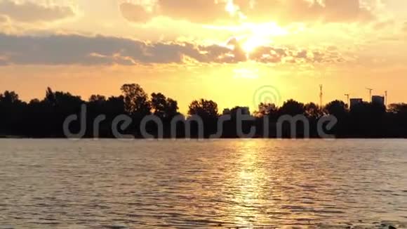 在河岸上的迪尼伯河上随着一片稀疏的水域灿烂的日落视频的预览图