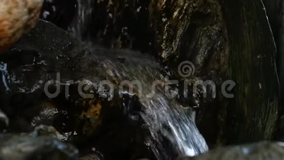 岩石山的小瀑布水在岩石小径上流淌慢动作视频的预览图