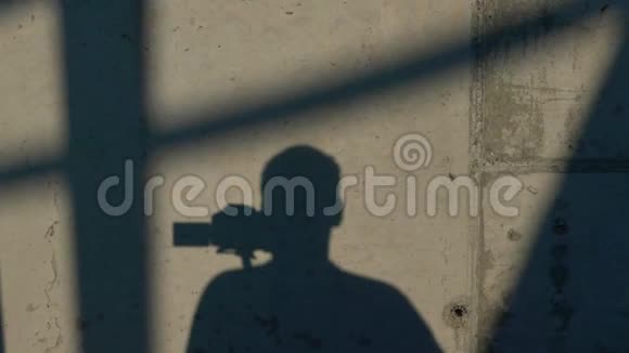 男人的影子用DSLR相机玩电子万向节视频的预览图