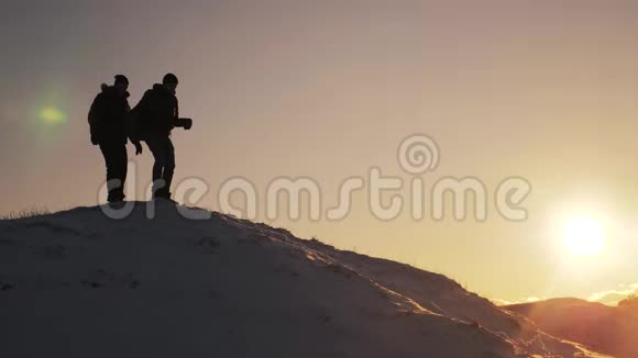 团队合作剪影商务旅行理念2两个徒步旅行者从登山者手中滑下来爬到山顶视频的预览图