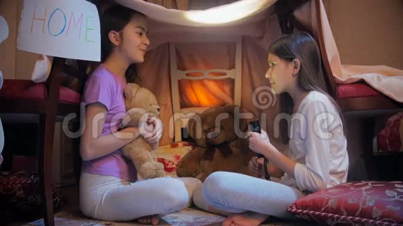 两个穿睡衣的女孩睡觉前用手电筒讲故事的4k视频视频的预览图