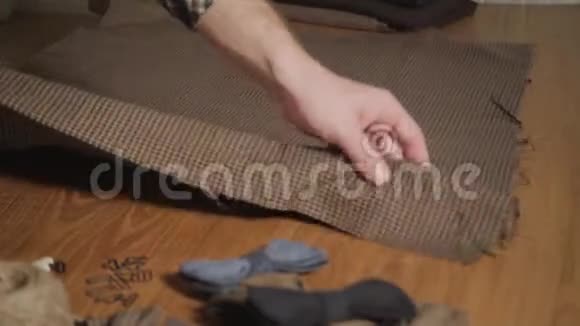 折叠棕色格子毛织物年轻人做裁缝在车间里使用缝纫机视频的预览图
