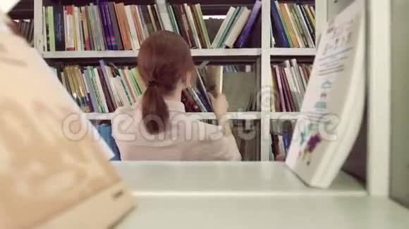 一位专注的大学女生来到书架前寻找一本书视频的预览图