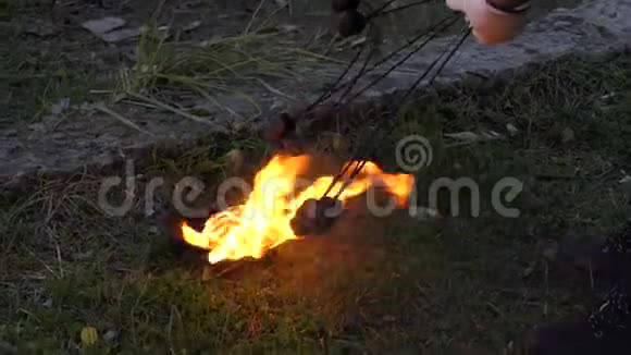 两把火把从一个碗里点燃火放在室外的陆地上视频的预览图