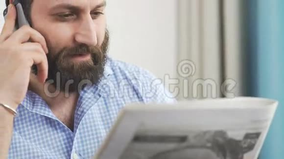 有胡子的人正在看报纸你在打电话视频的预览图