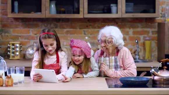 孙女和奶奶带着平板电脑在厨房视频的预览图