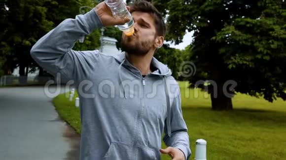健身男子饮用的水从瓶子溅水视频的预览图