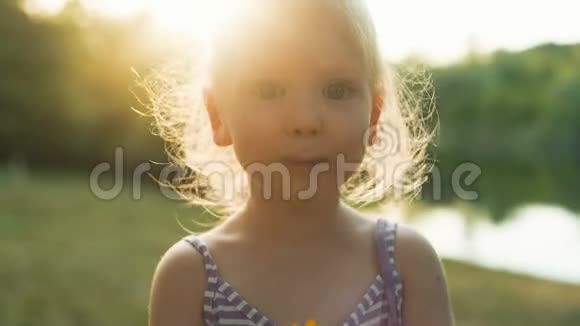 小女孩在日落时嗅花视频的预览图