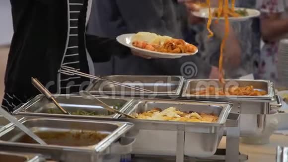 自助餐的人把食物放进盘子里视频的预览图