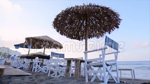 早晨在热带海滩上沙滩上有太阳伞和椅子背景是大海视频的预览图