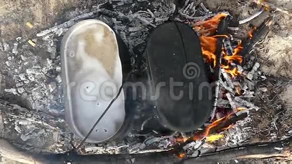 夏季在火灰上放两个带烧水的金属大锅视频的预览图