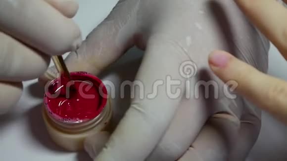 特写美甲师把红色凝胶指甲油混在一起美容美发沙龙做美甲的女人视频的预览图