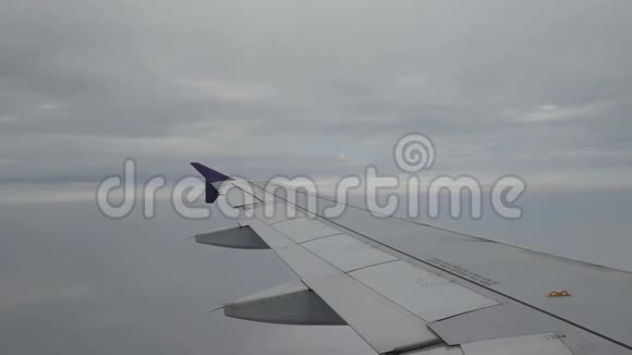 从飞机窗口到飞机机翼的视图飞机在云上飞行视频的预览图