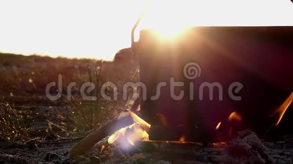 宽敞的大锅矗立在篝火中日落时分它缓慢地搅动着海水视频的预览图