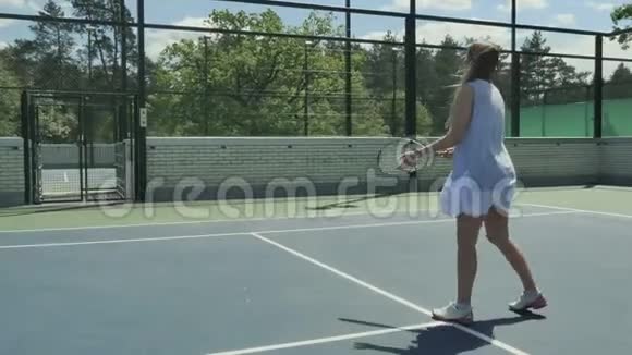 年轻女孩在户外的网球场消磨闲暇时间视频的预览图