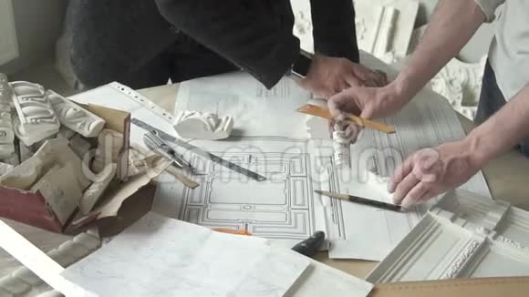 两名男性建筑师用白色石膏做手视频的预览图