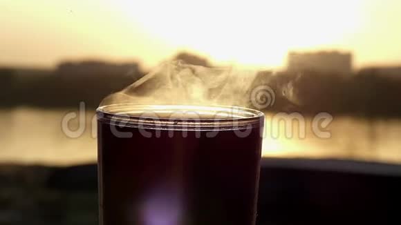 在灿烂的夕阳下在湖畔的一杯热咖啡视频的预览图