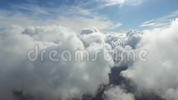 奇妙的空中无人机4k相机在山上晴朗的蓝天中通过蓬松的白色雨云高高飞起视频的预览图