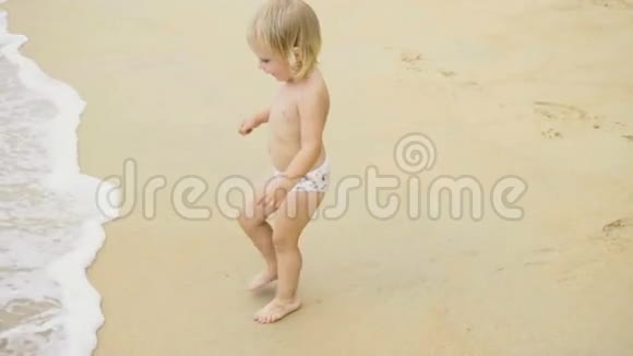 可爱的女孩在海岸线上踏足视频的预览图