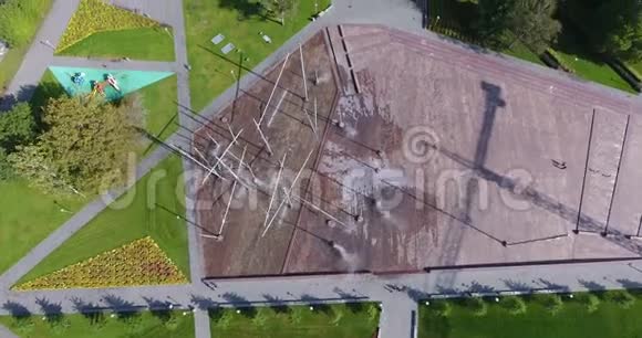 有喷泉绿地树木和停车场的空中城市景观4K无人机射击视频的预览图