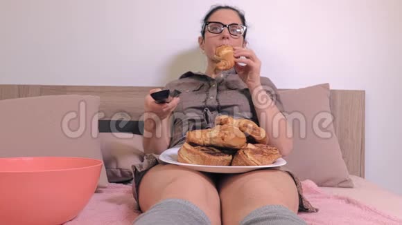 女人看电视吃垃圾食品视频的预览图