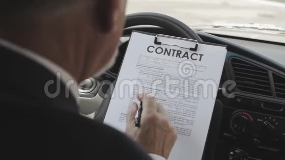 商人坐在车里读和签合同视频的预览图