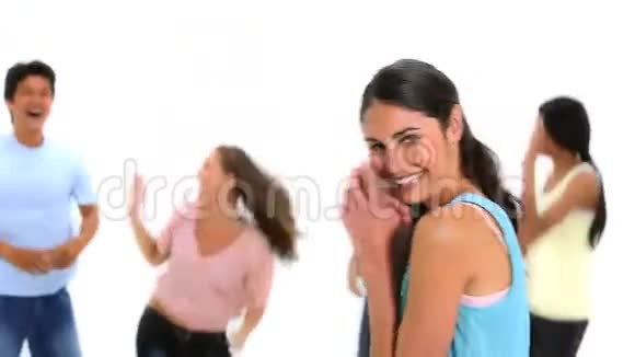 笑着的黑发女人和朋友们跳在她身后视频的预览图