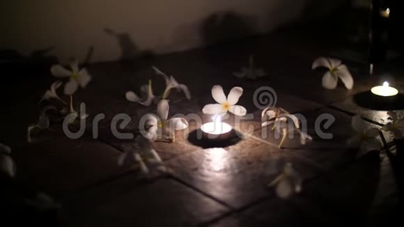 靠近漂亮的夜晚装饰在地板上安排蜡烛和布局花白色木兰浪漫视频的预览图