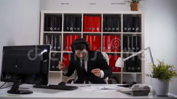 商人戴着耳机在办公室跳舞视频的预览图