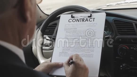 商人坐在车里读和签合同视频的预览图