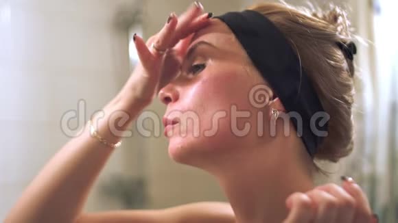 年轻女子在浴室里做面部按摩视频的预览图