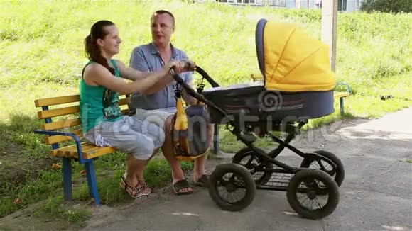 幸福的家庭摇着婴儿车视频的预览图