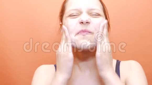 年轻女子用洗脸肥皂擦洗洗脸4UHDK视频的预览图