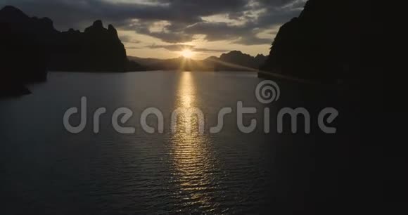 一个热带湖泊的水面日落背景下的山脉悬崖和岩石上的船只之旅KhaoSok国家公园SuratTha视频的预览图