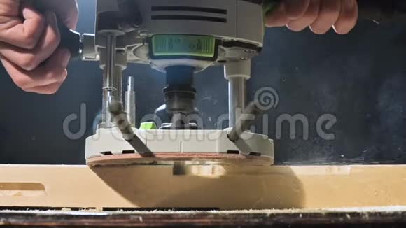 大特写木工用电铣锯切木板尘埃粒子和锯子的缓慢运动视频的预览图