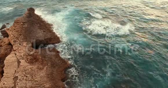 海上的石岛日落时相机飞到岛上视频的预览图