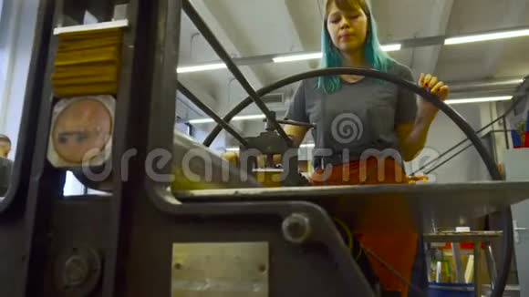 年轻的女设计师在一个有印刷机的车间工作视频的预览图