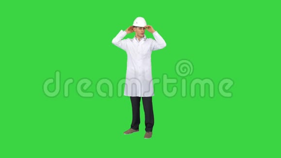 在绿色屏幕上跳舞带头盔的年轻工程师色度键视频的预览图