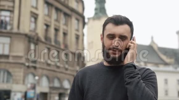 男人谈论他的智能手机在城市里走动视频的预览图