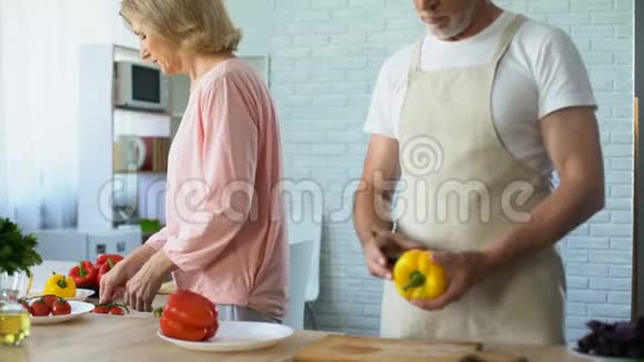 老人和爱人在厨房里做健康的蔬菜午餐视频的预览图